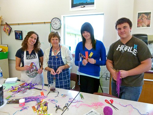 DTSS art teacher Robyn Oliver (far left) and artist Angelique Gillespie (middle-left) lead students in making memorial bookmarks.