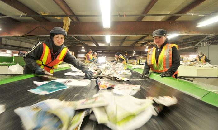 Workers sort out contaminants at Emterra Environmental's material recovery facility in Surrey. The plant is one of three that will process recyclables collected for Multi-Material BC.