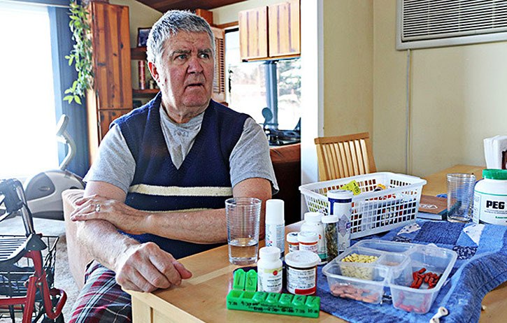 Former teacher Barry Mansfield sits in his home