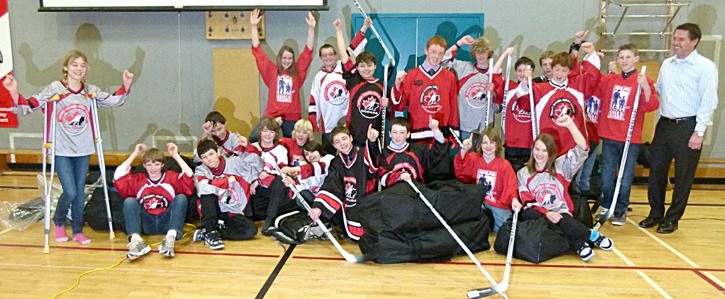 Kelly Hrudey (far right) poses with an excited group of HCSA students and their new hockey equipment at J.A. Laird on February 22.