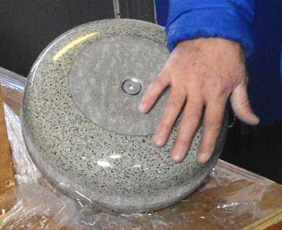 Curling technician Dave Merklinger shows the fine points of a Kays of Scotland curling stone at the Memorial Arena in Cranbrook. Preparations for Pinty's Grand Slam of Curling are well underway.