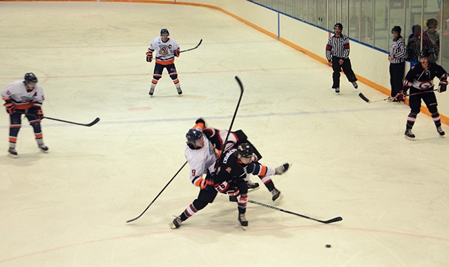 Rockies forward Matt Houston is taken out of the play by two Kimberley Dynamiters during the home game on Saturday