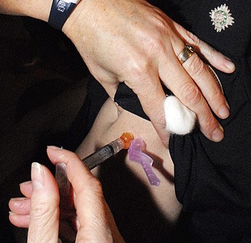 Police officer receives a flu shot at the B.C. legislature. Emergency services personnel are immunized every year