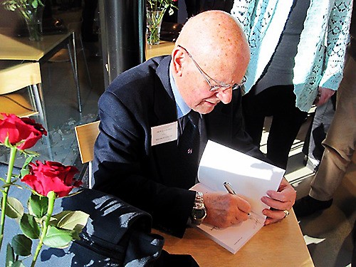 Fred Van Suiden signs a copy of his book