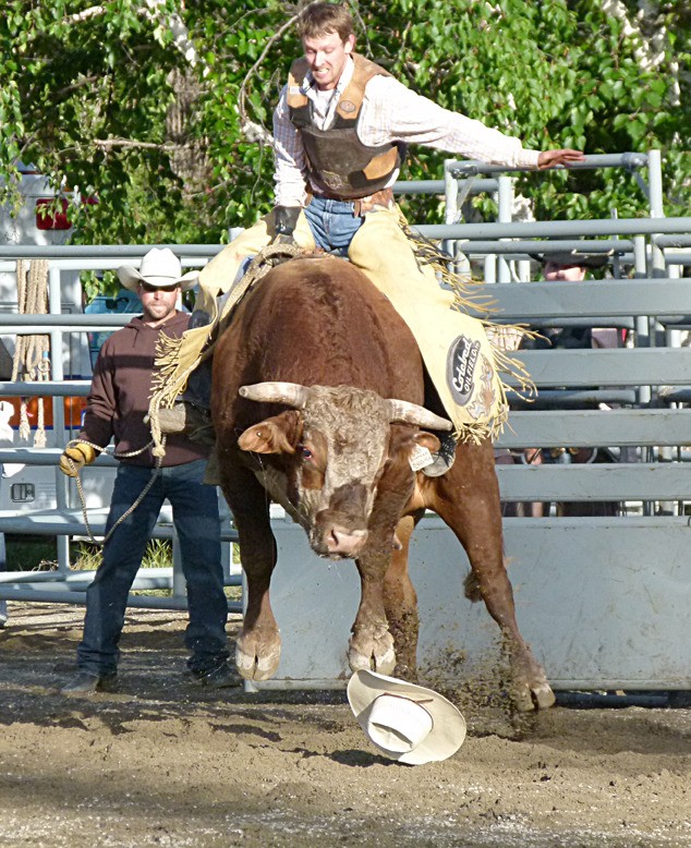 A rider holds strong on a bucking bronco.
