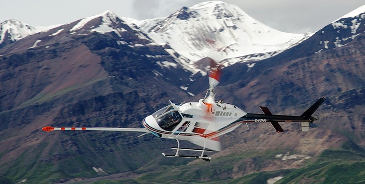 Helicopter maps mineral potential in remote areas using magnetic imaging.