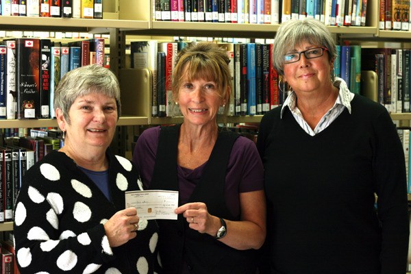 Susan Webster and Joan Rouse (left and right) present head librarian Liz Robinson with a cheque.
