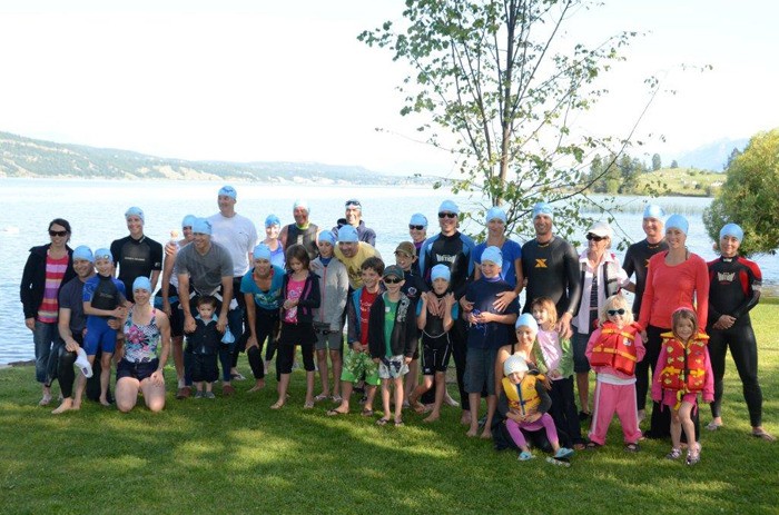 A group of family and friends who swam across Lake Windermere in honour of Jay Carscadden in July pose before the swim in front of the tree at Windermere beach that was planted in Jay's memory.