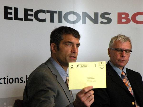 Assistant chief electoral officer Anton Boegman shows postage-paid envelopes voters will use to mail HST referendum ballots in to be counted.