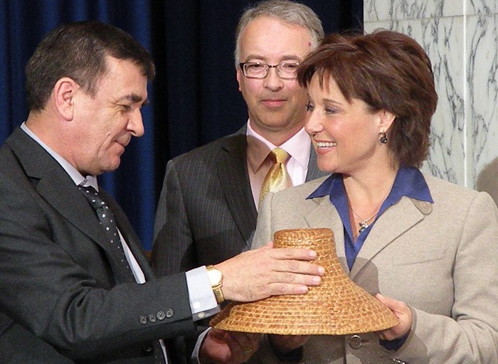Garry Reece of Lax Kw'alaams First Nation presents cedar bark hat to Premier Christy Clark as Aboriginal Relations Minister John Rustad looks on at revenue sharing ceremony at the B.C. legislature April 9. It was the latest of a long series of B.C. resource revenue agreements