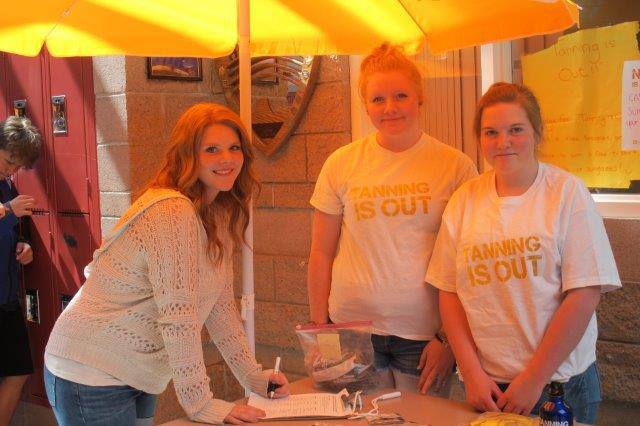 David Thompson Secondary School Grade 10 student Lauren Phillips (left) signs the pledge form to go tan-free for 2013