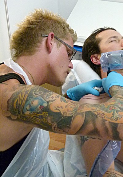 Nik Hylo works on a client at Fire Vixen Tattoos.