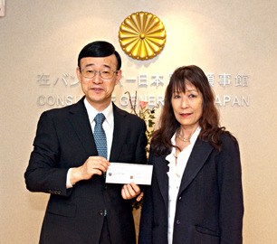 Consul General of Japan in Vancouver receiving a cheque from Chizuko Purschwitz.