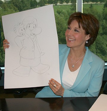 Premier Christy Clark shows a cartoon portrait of her drawn at a campaign stop at Disney Interactive studio in Kelowna Tuesday.