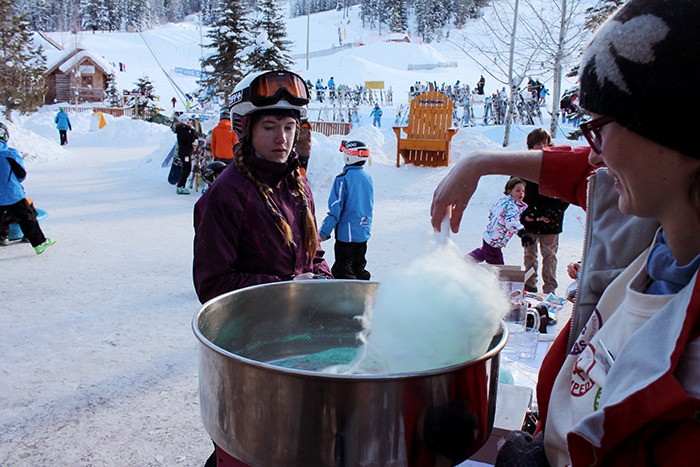 One boarder satisfies her sweet tooth with some cotton candy at the Panorama Snowflake Festival on Saturday