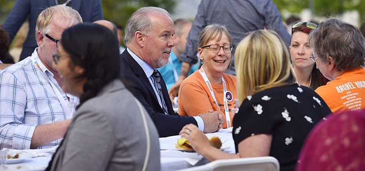 NDP leader John Horgan dines with party supporters Saturday at a party conference in Kamloops.