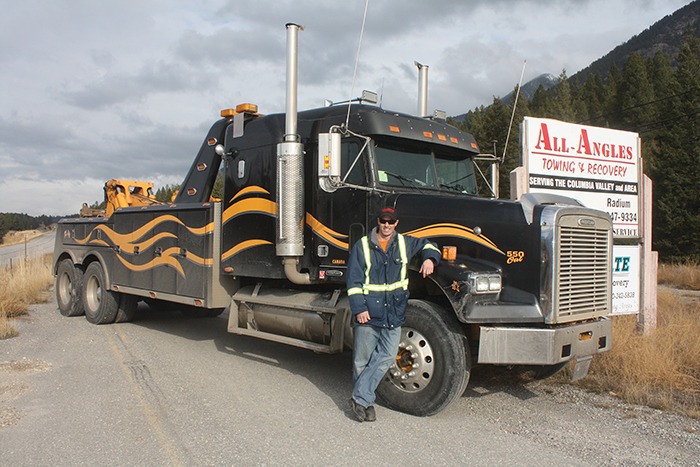 Blair Mooney of All Angles Towing stands next to his new 30-ton hydraulic wrecker.