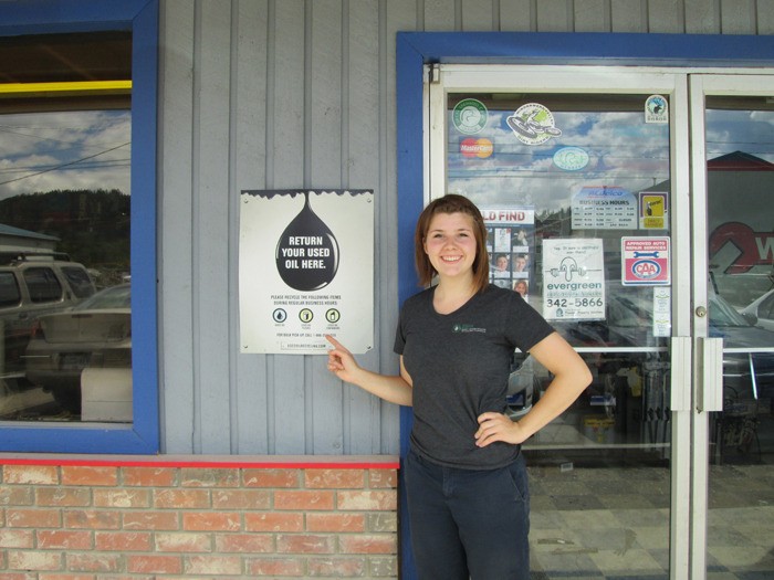 British Columbia Used Oil Management Association ambassador Ali Omelaniec points to a sign her two-person team posted at Walker's Repair Centre in Industrial Park on June 12 as part of their summer survey tour.