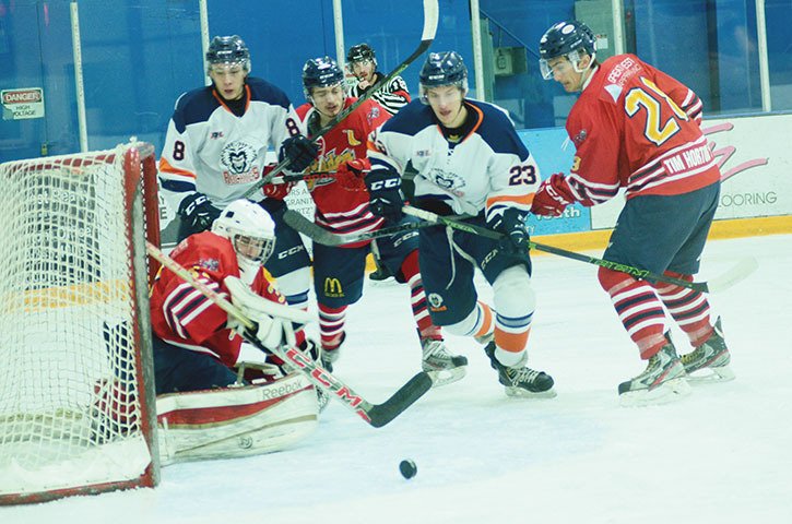 Rockies forward Nolan Menard (#23) charges the puck in front of the Golden Rockets’ net on February 3rd at the Eddie Mountain Memorial Arena in Invermere with Rockies forward Nick Hoobanoff (#8) looking on. The Rockies won 5-1.