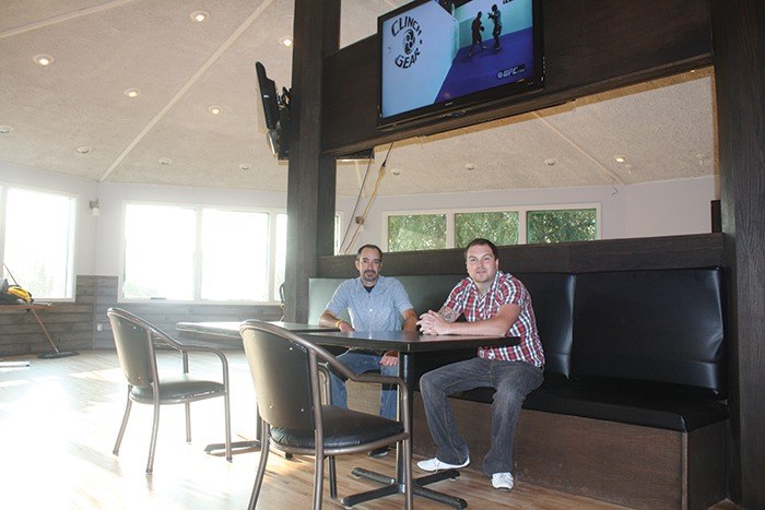 Jason Powers (left) and Josh Page sit in front of one of the 60 inch televisions they've set up in the refinished dining area of the Station Neighbourhood Pub