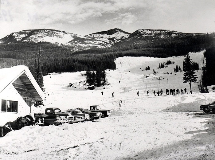 PANORAMA MOUNTAIN VILLAGE photo A collection of now-classic cars sit in the parking lot as skiers cruise down the Old Timer ski run at Panorama in the 1963-1964 season . The mountain looked a little different back then