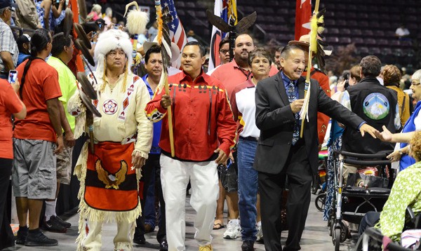 Grand Chief Stewart Phillip of Penticton reaches out to an audience member during the grand entry of the delegates to the 2014 BC Elders Gathering at the South Okanagan Events Centre.