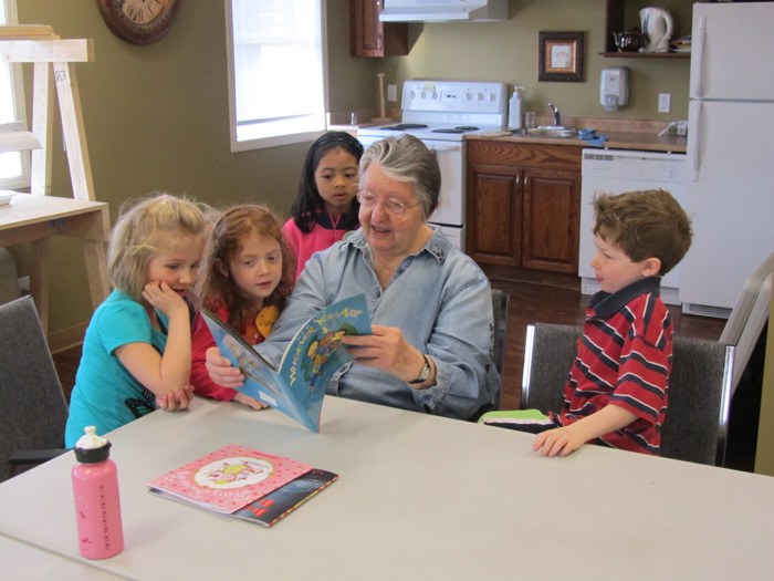 A Columbia Garden Village resident reads to Eileen Madson Primary students as part of the school's award-winning Intergenerational Project.