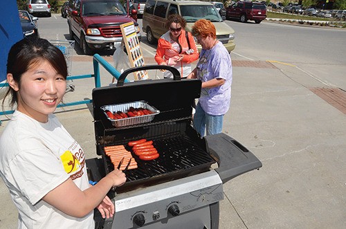 Japanese student Eri Hirokawa mans the barbecue at the AG Valley Foods ICAN fundraiser on Saturday