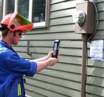 Smart meter installer photographs a sign posted to refuse replacement of mechanical power meter