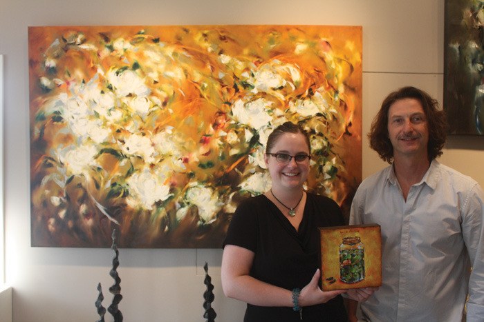 Employee Deanna Berrington and owner Grey Bradatsch show off two of the pieces in the Artym Gallery's 'Top Secret Show' running until September 7.