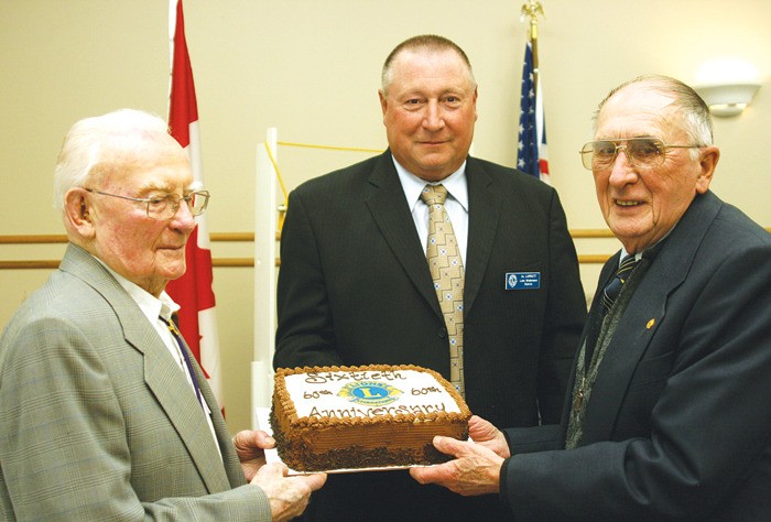 Current Lions president Al Larratt (middle) and charter members Gordon Lake and Joe Fuller get ready to cut the club's 60th birthday cake.