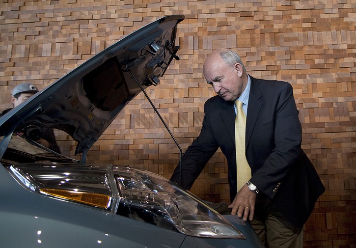 Energy Minister Bill Bennett looks at the power system of a plug-in electric vehicle on display at the Vancouver International Auto Show.