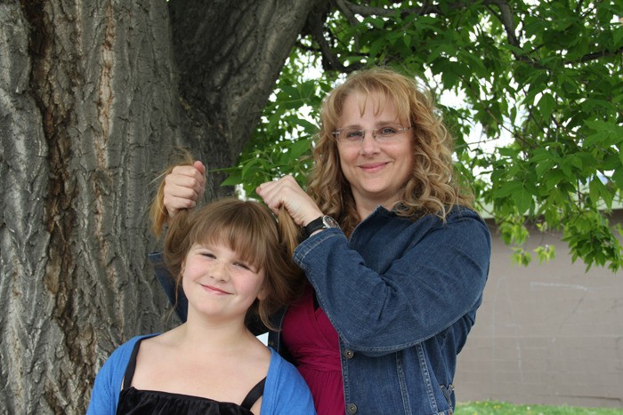 Terri Lightfoot holds up her daughter Taylor's hair to show what she'll look like after this year's Columbia Valley Relay for Life event. Taylor