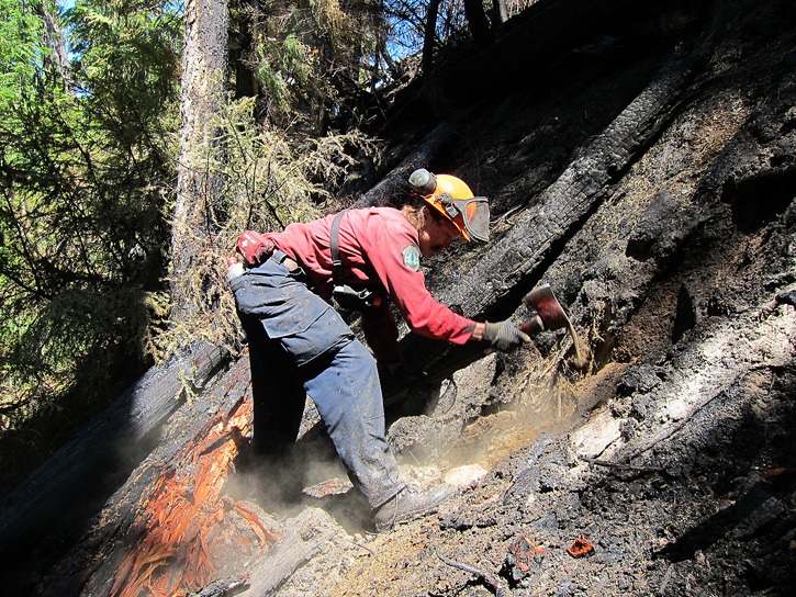 A firefighter works on steep terrain to contain the Elaho forest fire near Pemberton.