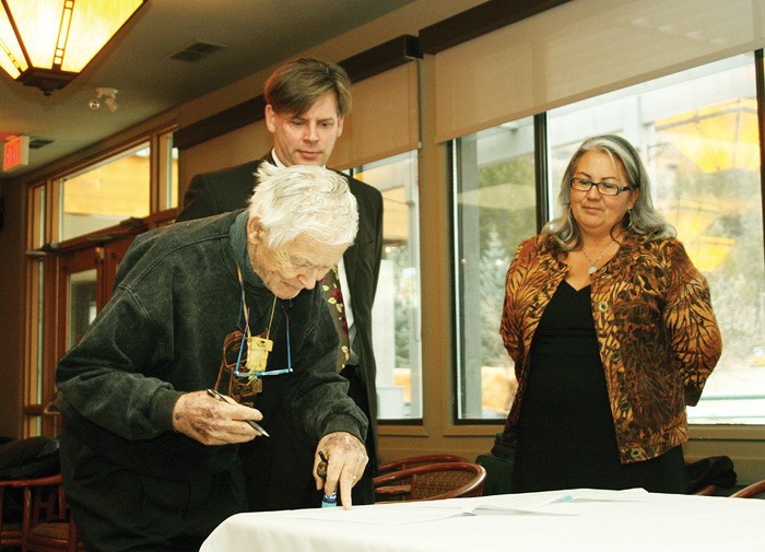 WoodEx Industries Ltd.'s Ike Barber signs a working protocol with the Akisqnuknik Development Corporation November 24 at Radium Resort as the mill's president and CEO Douglas Riddell and development corporation CEO and president Lillian Rose look on.