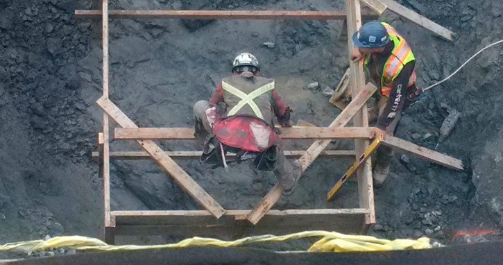 Construction workers in underground portion of commercial-residential building