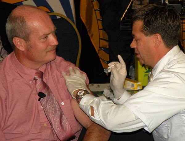 B.C. Health Minister Mike de Jong gets his flu shot from pharmacist David Pavan at the B.C. legislature Monday.