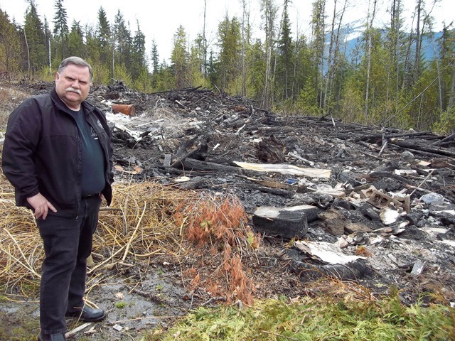 Nakusp Fire Chief Terry Warren inspects the site of a case of suspected arson and illegal dumping on Highway 6 near Nakusp.