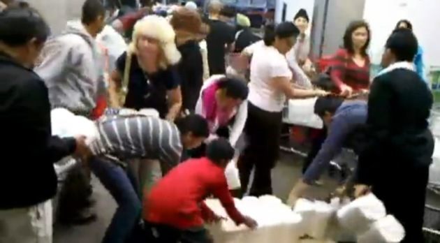 Canadians swarm a newly dropped pallet of milk at a Bellingham Costco.