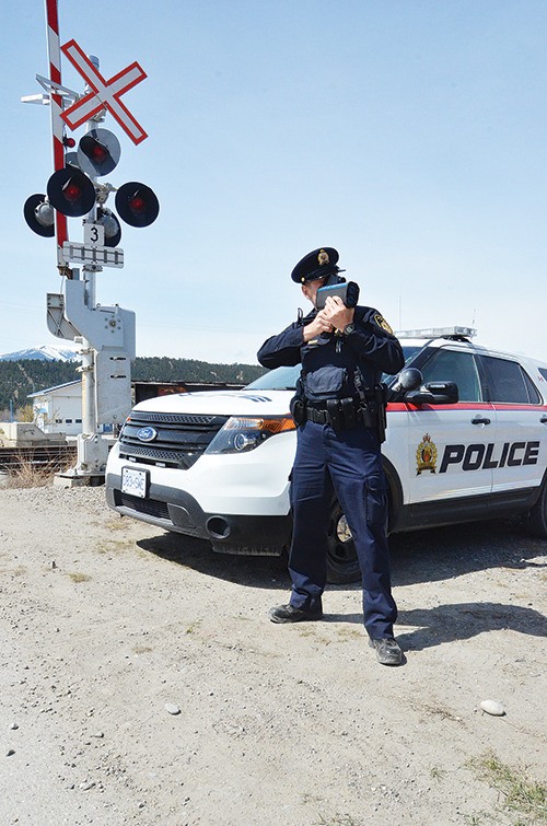 Constable Michael Crockett from the Canadian Pacific Police Service aims a radar gun at traffic headed towards n Athalmer railway crossing on Thursday