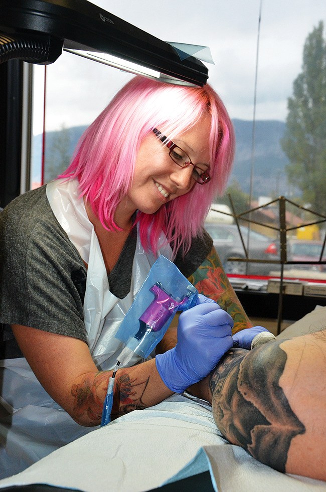 Fire Vixen Tattoo owner Sarah Eastick works on a Grim Reaper image on the shoulder of a client.