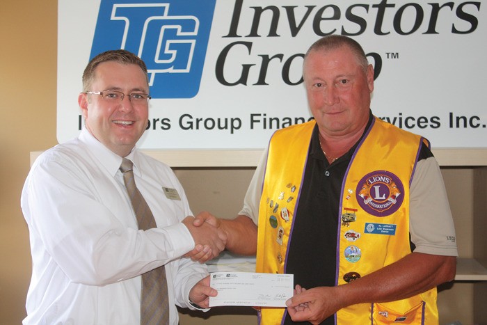 Jason Stevens with the Investors Group presents a cheque for $250 to Lake Windermere and DIstrict Lions' Club past president Al Larratt on August 24 as part of James Easthams' hole in one prize. For the full story