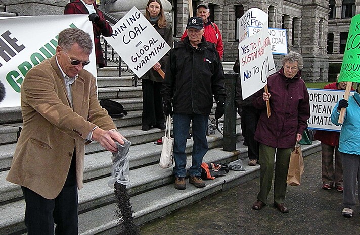 Peter Nix pours a bag of coal onto a blanket at the B.C. legislature Tuesday