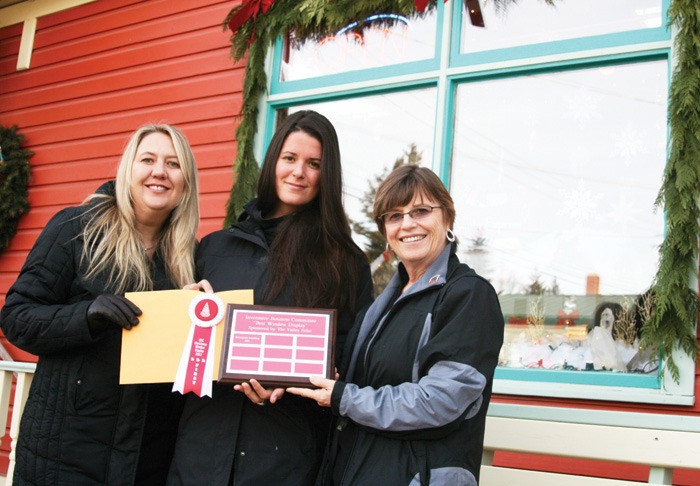 Carole Georgeson and Jacqueline Moiler of River Gems accept the first place prize for the 2011 Window Display Decorating Contest from Valley Echo publisher  Marilyn Berry.