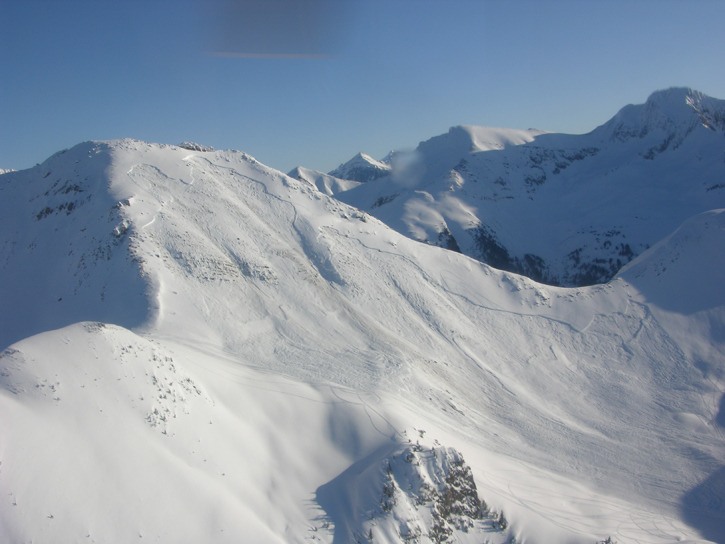 An aerial image of the avalanche that killed three on Mt. Gerald on Feb. 19. Snowmobile tracks are faintly visible in several spots on the slope. High-marking loops are visible just above the fracture line and just below the ridge at the centre of the picture.