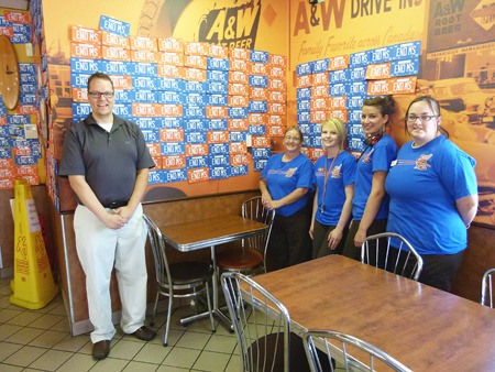 Jarret Nixon (left) and staff stand with some of the Invermere A&W restaurant's walls that have been covered in signed license plates. These plates were given out for signature and collected back for every $1 donated to MS research.