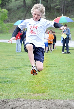 A student leaps for victory in the long-jump event at the school track-and-field meet.