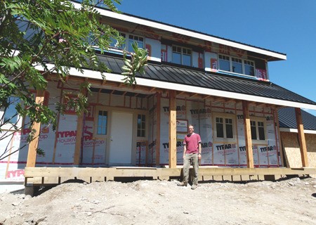 Cam Gillies stands outside his progressing 'green' home in Windermere.