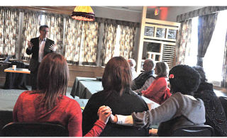 Windermere resident Crisdon Chaisson holds hands with a family member while listening to Liberal leadership hopeful Kevin Falcon speak at the Best Western Invermere Inn. Falcon was in town to talk to residents as part of a tour leading to the vote happening on February 26. Darryl Crane/echo photo