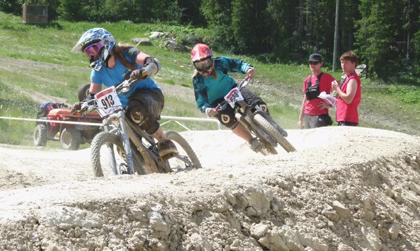 Two bikers almost go head-to-bike on a sharp turn on the downhill track.